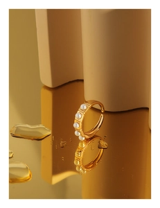 Detail of gold-plated silver ring with five small pearls and vintage engraved texture