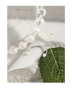 Detailed view of silver open pearl ring featuring dual white pearls on stone surface
