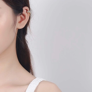 Chic dolphin ear cuff in gold finish with sparkling zircons worn by a model