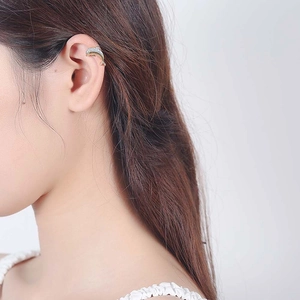 Elegant gold dolphin ear cuff with sparkling zircon accents on a female model