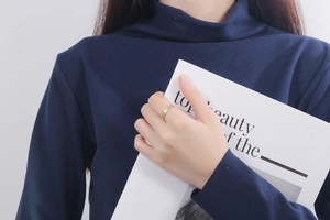 Gros plan d'une bague dorée minimaliste texturée avec finition brossée sur un mannequin