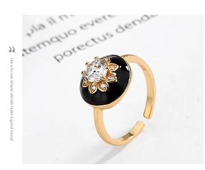Macro view of gold S925 ring featuring black enamel inlay and sparkling crystal center