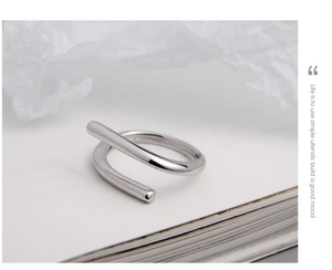 Detail of minimalist S925 silver spiral ring with polished finish and round ends