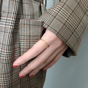Detailed view of a gold-plated twisted rope band ring worn on a finger for daily styling