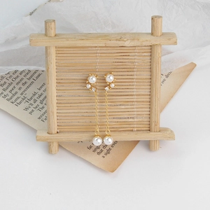 Detail of S925 silver pearl tassel earrings with gold plating and cubic zirconia