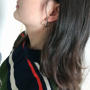 Detail of minimalist S925 sterling silver geometric stud earring worn by a model