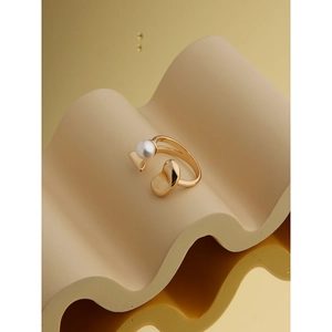 Bague perle dorée artistique avec design minimaliste sur un fond chaud élégant