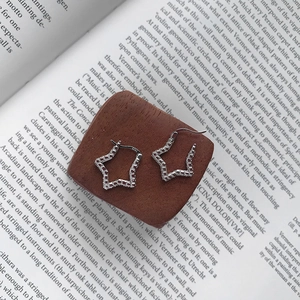 Macro shot of S925 sterling silver star stud earring with shimmering pave zircon details