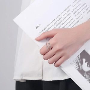 Minimalist S925 sterling silver open double-line ring on a model holding a magazine