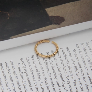 Close-up of golden S925 sterling silver twisted rope ring with adjustable open design
