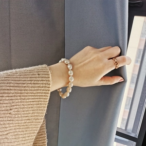Baroque pearl bracelet and golden chain ring set for women on model wrist