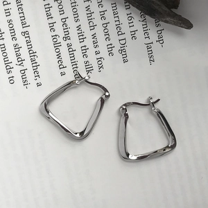 Macro view of S925 sterling silver geometric earrings with sleek faceted surface
