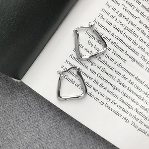 Macro shot of geometric S925 sterling silver earrings with polished faceted surface