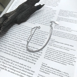 Detail of S925 sterling silver double-layer bracelet with flat beads on a vintage book