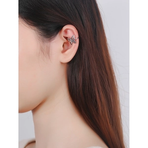 Elegant hollow butterfly ear cuff in silver metal finish worn on the ear cartilage