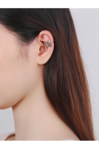 Detailed close-up of a vintage silver butterfly ear cuff worn on a model's ear cartilage
