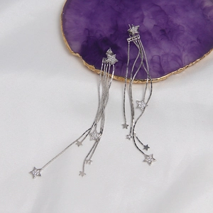 Detailed view of silver star tassel earrings with zircons on purple agate and silk