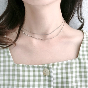 Dettaglio della collana minimalista a doppio strato in argento S925 con perle piatte