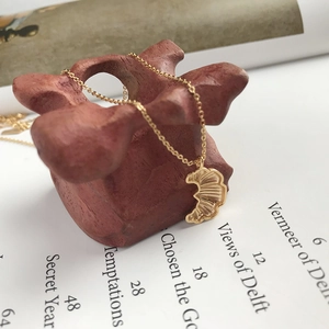 Elegant gold croissant moon pendant necklace with pleated texture on artistic background