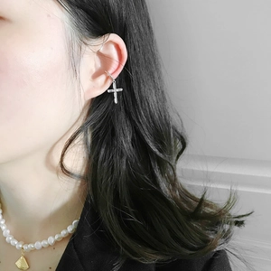 Detail of S925 silver cross earring with clear zircon inlay worn by model