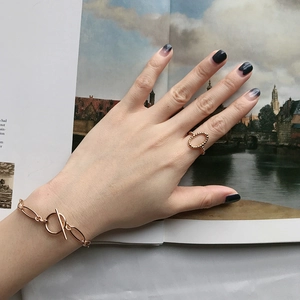 Détail d'une bague perlée en or rose et d'un bracelet à maillons avec fermoir OT