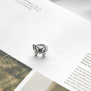 Macro shot of retro silver hollow butterfly ear clip with vintage textured finish