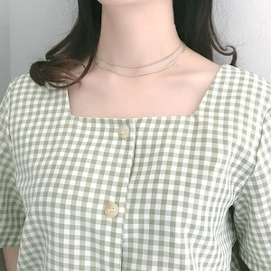 Primo piano della collana doppia minimalista in argento sul collo della modella