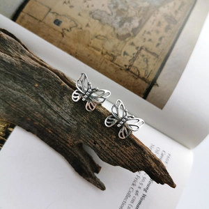 Detail view of vintage butterfly clip-on earrings with hollow carved silver texture