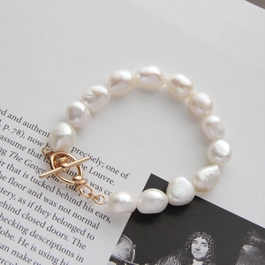 Detailed view of natural Baroque pearl bracelet with elegant golden T-bar toggle clasp