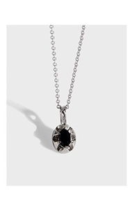 Gros plan d'une chaîne en argent S925 avec un pendentif ovale en pierre noire