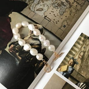 Close-up of natural baroque pearl bracelet with gold OT toggle clasp on vintage art book