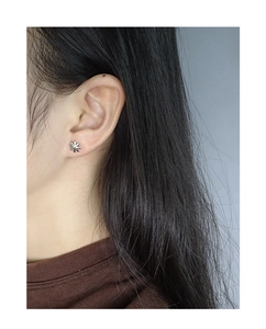 Close-up of a model wearing minimalist silver star stud earrings in S925 sterling silver
