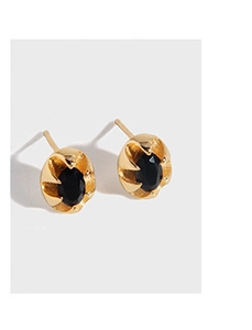 Détail de boucles d'oreilles vintage dorées avec gemmes noires ovales et gravures pétales