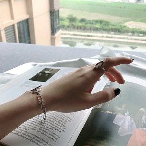 Détail d'un bracelet à chaîne en T et d'une bague à maillons assortie sur un mannequin