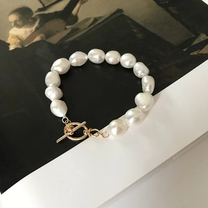 Detailed view of natural baroque pearl bracelet with elegant golden OT clasp closure
