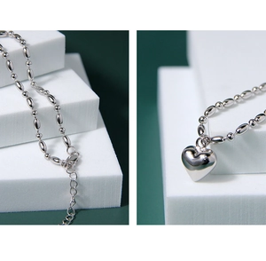 Detail of silver heart pendant and beaded olive chain with lobster clasp and extender