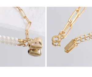 Detail showing S925 sterling silver stamp on golden heart and pearl necklace closure