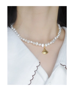 Gros plan d'un collier en argent S925 avec perles baroques et pendentif éventail doré