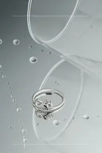Dettaglio anello infinito in argento S925 con pietre di zircone su superficie d'acqua