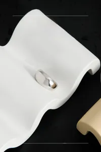 Gros plan d'une bague minimaliste en argent 925 sur support ondulé blanc