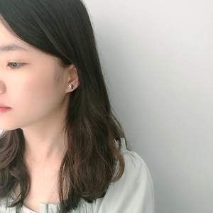 Minimalist S925 sterling silver daisy stud earring worn on model's ear for feminine look