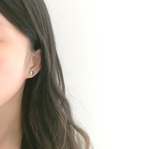 Elegant S925 sterling silver daisy stud earrings shown worn on a model's ear
