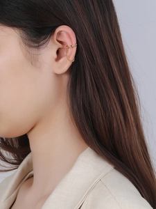 Close-up of minimalist gold ear cuff with elegant chain detail on model's ear