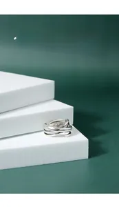 Detailed view of S925 sterling silver multilayer layered ring on a white display stand