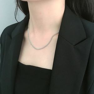 Close-up of minimalist 925 sterling silver curb chain choker on model neck in black suit