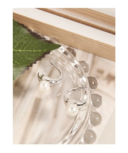 Detailed macro view of S925 sterling silver hoop earrings with white round pearls
