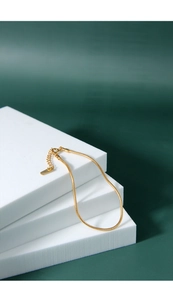Detailed view of a gold snake bone bracelet with fine texture and branded tag