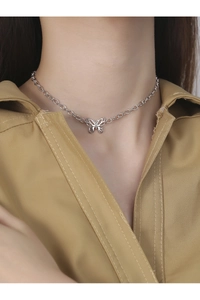 Gros plan d'un ras de cou papillon en argent S925 sur le cou avec chemise kaki