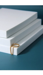 Detailed close-up of a gold chain link ring featuring a long dangling metal drop chain