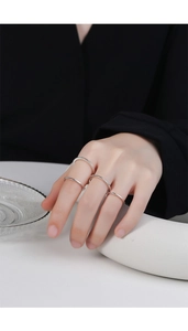 Minimalist silver stackable rings set on model fingers with a glossy polished finish